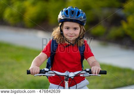 Little Kid Boy Ride A Bicycle In The Park. Kid Cycling On Bicycle. Happy Smiling Child In Helmet Rid