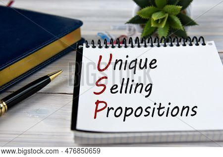 Unique Selling Propositions - Words In A Notebook On The Background Of A Weekly, A Pen And A Cactus