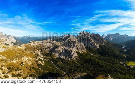 Rocky Mountain Peaks Under Blue Sky With White Clouds. Covered With Grey Sand Deep Canyons. Mountain