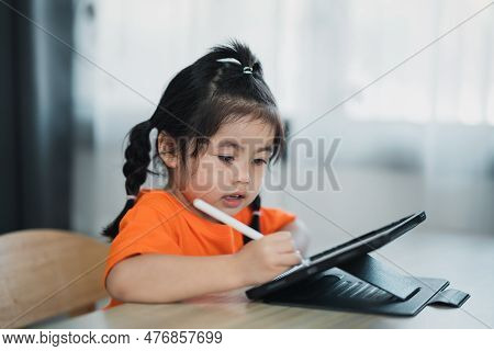 Asian Girl Use Digital Pen And Touch On Screen Tablet Screen Attentively. Overstimulated Children Co