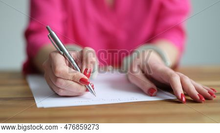 Female Hands In Metal Handcuffs Writing Explanatory Note Closeup. Court Detention Law Concept