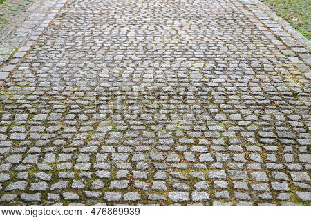 An Old Stoneblock Pavement Cobbled With Rectangular Granite Blocks As A Background. Photo In Perspec