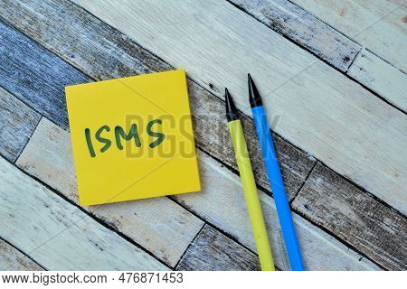 Concept Of Isms Write On Sticky Notes Isolated On Wooden Table.