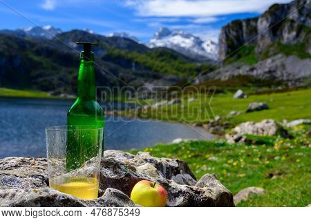 Green Bottle And Glass Of Natural Asturian Cider Made From fermented Apples With View On Covadonga L