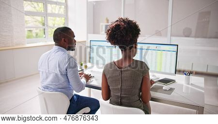 Analyst Employee Working On Spreadsheet Using Desktop Computer