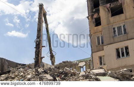 Excavator With Hydraulic Crusher At The Demolition Of A Residential Building. City Renewal. Dismantl