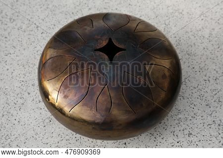 Steel Tongue Drum On Grey Table. Percussion Musical Instrument