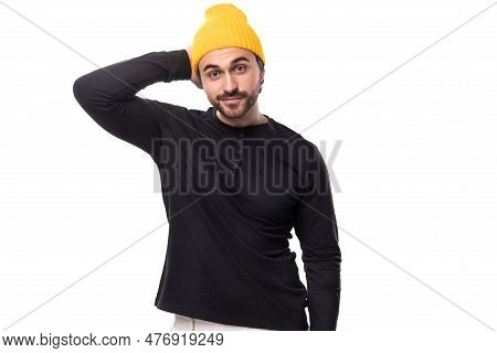 Successful 30s Authentic Brunet Male Adult In Black Sweater And Yellow Cap On White Background With 