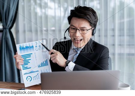 Confident Asian Telesales Businessman Work In Modern Office Wearing Headphone, Presenting Bi Dashboa