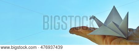 White Paper Origami Bird On Blue Sky Background. World Day Of Peace. Day Against Humiliation. Intern