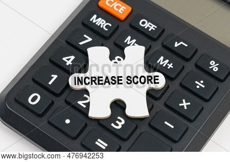 Business Concept. On The Calculator Is A Puzzle With The Inscription - Increase Score