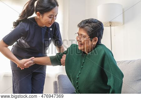 Mature Woman Suffering From Bone Backache Or Stiff Muscles, Young Caregiver Care Supporting Elderly,
