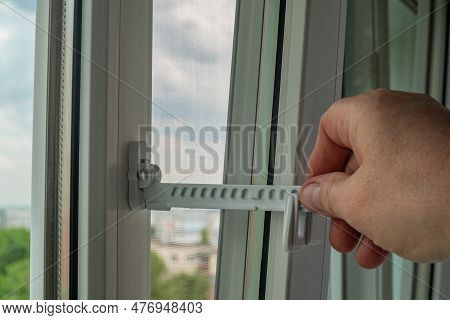 Master Installed Fixing Limiter For Opening A Plastic Window And Checks Its Operation. Close-up Of A