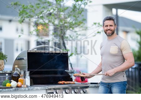 Hispanic Man Cooking On Barbecue In The Backyard. Chef Preparing Barbecue. Barbecue Chef Master. Man