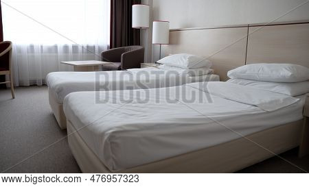 A Room With Beds In A Hotel. Beds In A Clean Hotel Room. Two Single Beds In A Cozy Hotel Room. Two E