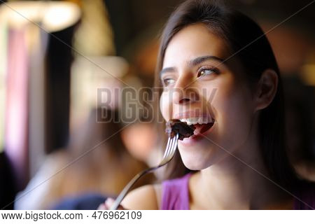 Happy Woman Eating Meat Using Fork In A Restaurant
