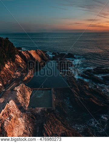Blue Pool Rock Pool In Bermagui, New South Wales. Aerial Drone Shot During Sunrise With Wam Colors. 