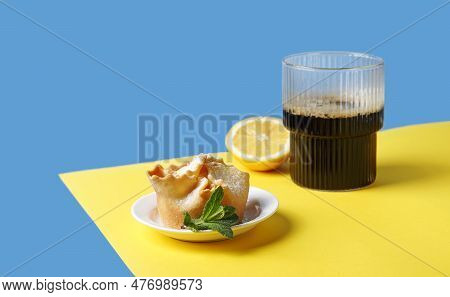 Soffioni Cake On The Plate With A Glass Of Coffe On The Yellow And Blue Background. Breakfast Minima
