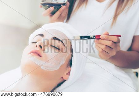 Beautiful Woman Having A Facial Cosmetic Scrub Treatment From Professional Dermatologist At Wellness