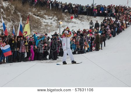 Novosibirsk, Russia - December 7: descent young man on snowboarding with the Olympic torch.