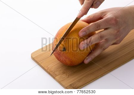 Knife In Position For A First Cut Through A Mango