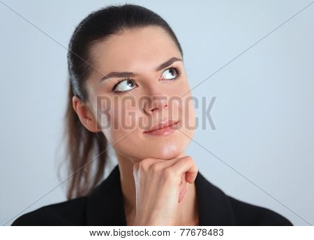 A young woman standing, isolated on graybackground