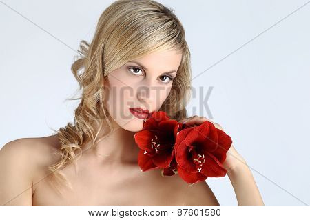 beautiful blond girl with red amaryllis flower on a white background