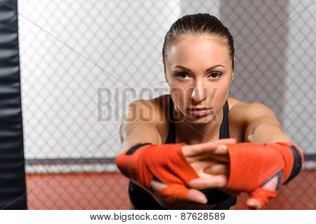 Female kickboxer poses at a ring