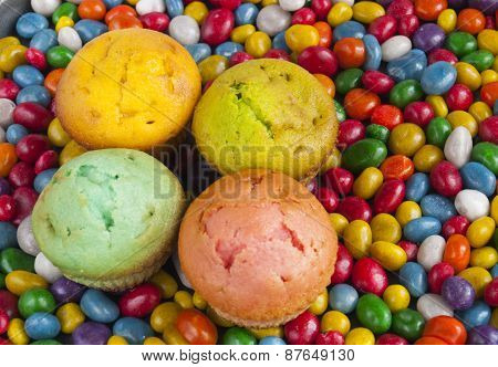 Delicious Muffins On A Background Of Colorful Candy