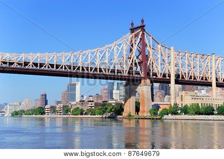 Queensborough Bridge in Midtown Manhattan with New York City skyline over East River as the famous landmarks viewed from Brooklyn.
