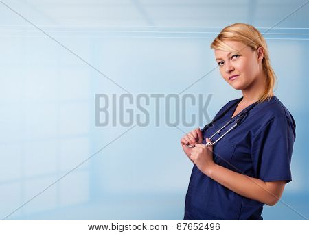Pretty young nurse in hospital listening to empty copy space with sthetoscope