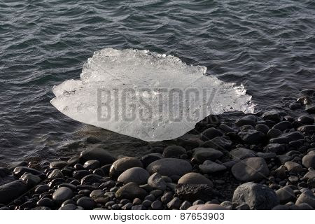 Melting ice block seen on the beach of the Jokullsarlon glacier lagoon in Iceland. The melting glacier ice is an important water source for earth coming from the ice age millions of years ago.