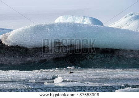 Glacier ice lagoon in Jokullsarlon, Iceland. The glacier breaks up into ice blocks in the lagoon before flowing out to sea as icebergs.