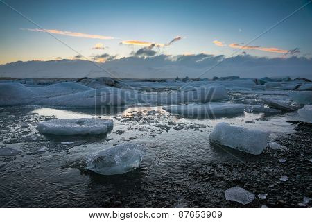 Glacier ice lagoon in Jokullsarlon, Iceland. The glacier breaks up into ice blocks in the lagoon before flowing out to sea as icebergs.