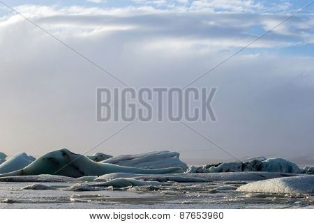 Glacier ice lagoon in Jokullsarlon, Iceland. The glacier breaks up into ice blocks in the lagoon before flowing out to sea as icebergs.