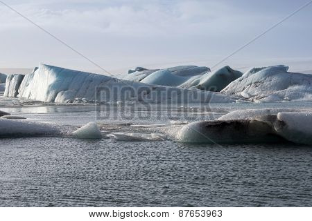 Glacier ice lagoon in Jokullsarlon, Iceland. The glacier breaks up into ice blocks in the lagoon before flowing out to sea as icebergs.