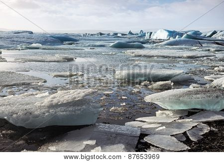 Glacier ice lagoon in Jokullsarlon, Iceland. The glacier breaks up into ice blocks in the lagoon before flowing out to sea as icebergs.