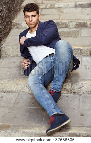 Handsome Young Man With Blue Eyes Posing Near A Wall