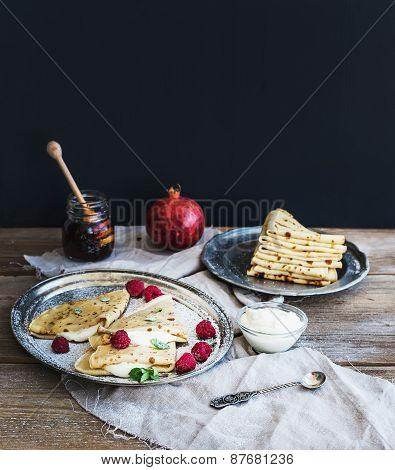 Thin Pancakes Or Crepes With Fresh Raspberry, Cream, Mint, On A Rustic Wooden Desk