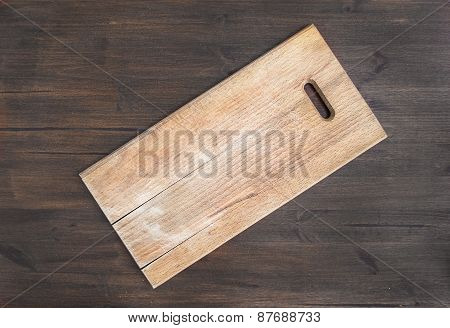 Rustic Square Wooden Cutting Board On A Dark Wooden Desk