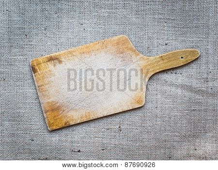 Rustic Wooden Cutting Board Over A Sackcloth Surface