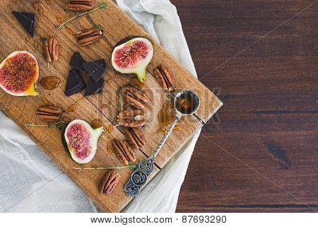 Fresh Figs And Pekan Nuts With Honey On A Wooden Board