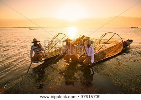 Three fishermen catches fish for food in sunrise in Inle Lake, Myanmar