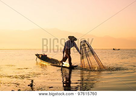 Three fishermen catches fish for food in sunrise in Inle Lake, Myanmar