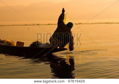 Three fishermen catches fish for food in sunrise in Inle Lake, Myanmar