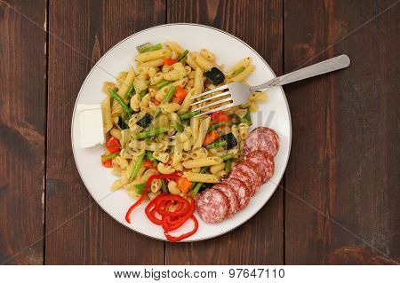 Penne With Green Beans, Red Hot Pepper, Salami And Feta Cheese With Fork In White Plate On Dark Wood