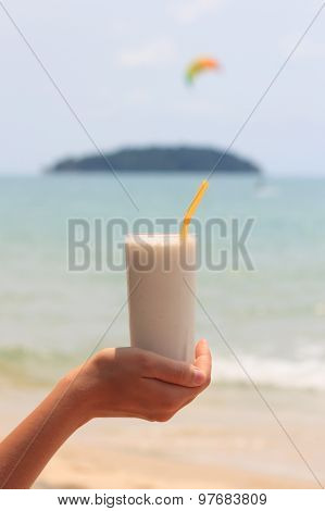 Female Hand Holding Milk Shake With Tropical Sea View Background