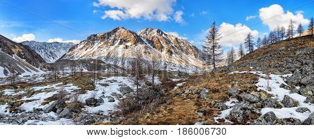 Nameless mountain peak and stream valley. Siberian alpine tundra in late April. Great Sayan. Munch-Sardyk. Russia