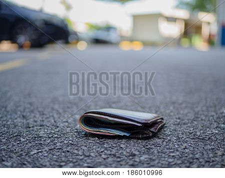 wallet with money drop on the street lost money concept copy space on top