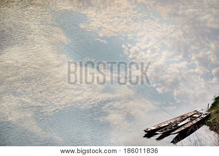 Three folk boats on riverbank and the reflection of the beautiful sky on the water of Song river wayside view between sidewalk travel .Vang ViengLaos